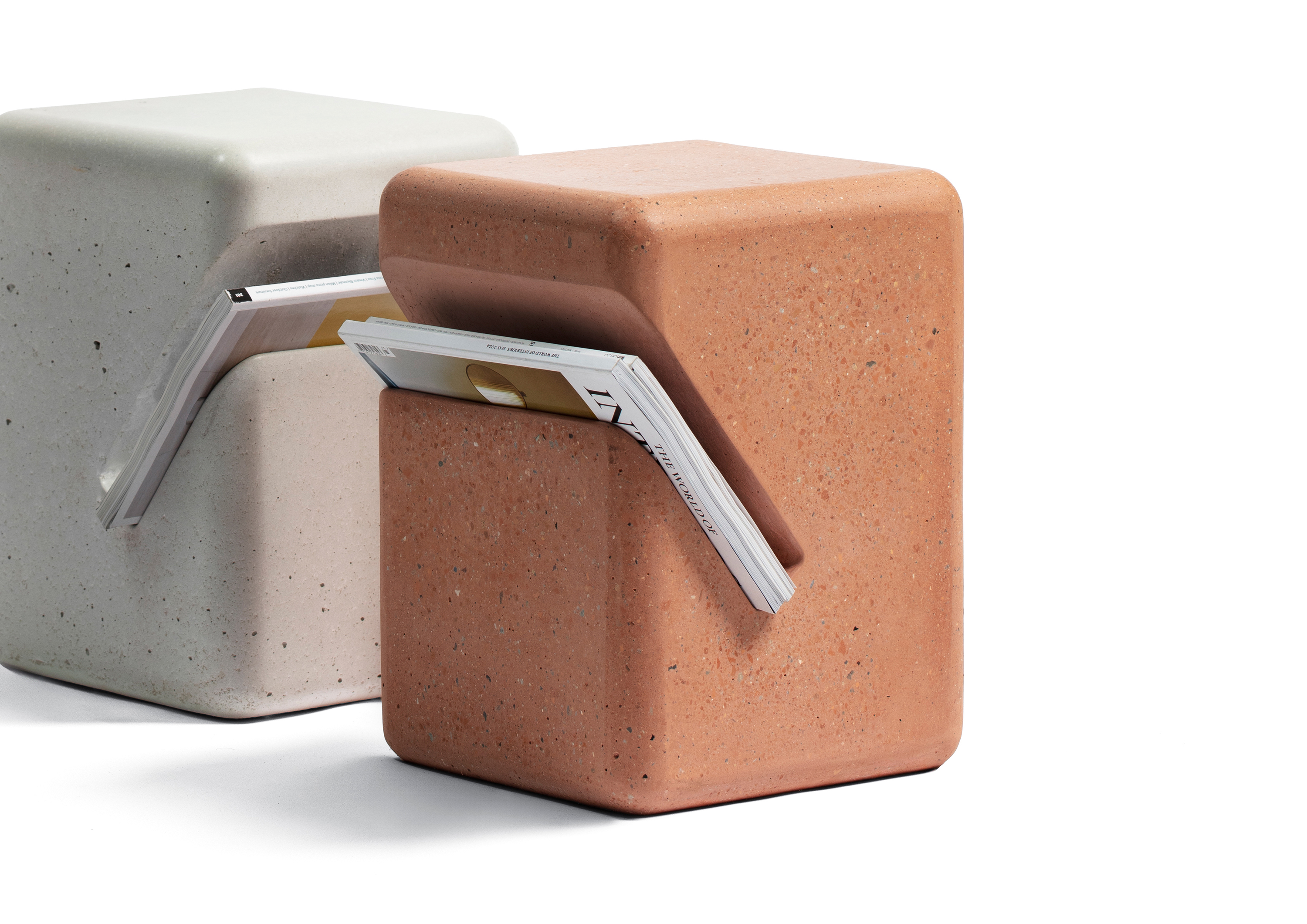 two concrete side tables with diagonal cut for magazines. one brick colour, one white